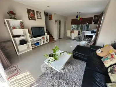 Spacious living room with modern decor and natural light, perfect for relaxation and entertainment.