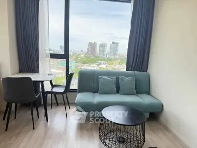 Modern living room with city view, stylish furniture, and large window for natural light.