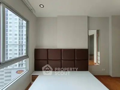 Modern bedroom with large window and minimalist design in urban apartment