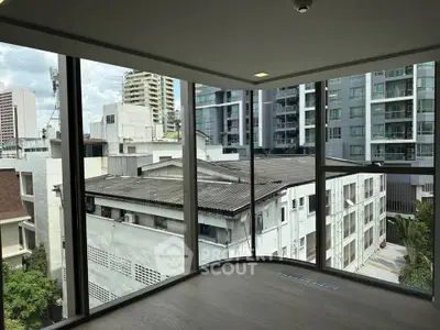 Modern corner unit with floor-to-ceiling windows offering urban city views.