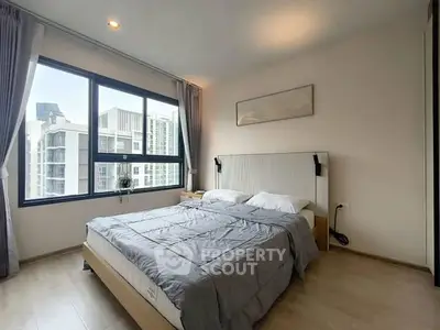 Modern bedroom with large window and stylish decor in urban apartment