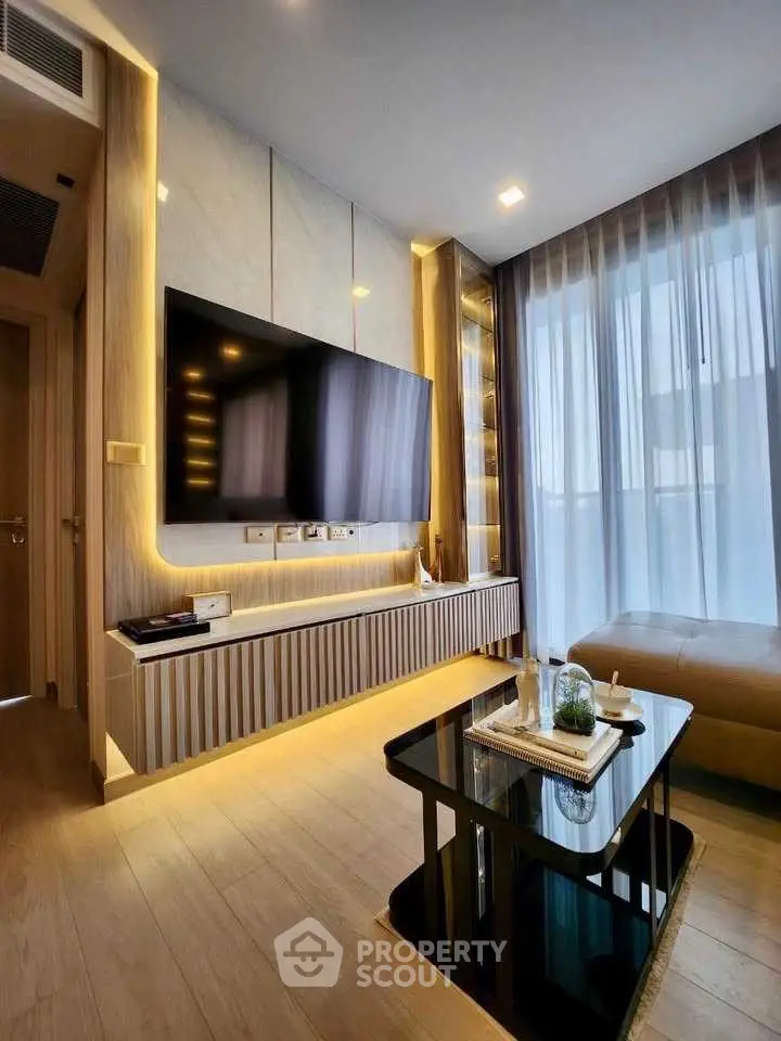 Modern living room with sleek TV setup and elegant lighting, featuring floor-to-ceiling windows and stylish decor.
