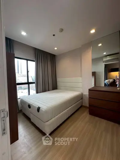 Modern bedroom with large window and stylish furniture in urban apartment