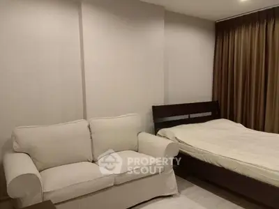 Cozy bedroom with a comfortable sofa and elegant bed, perfect for relaxation.