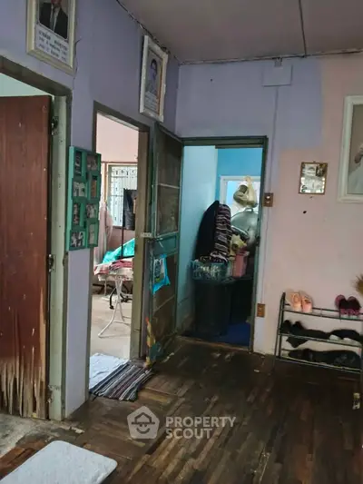 Cozy interior with wooden flooring and open doorways, showcasing a lived-in home atmosphere.