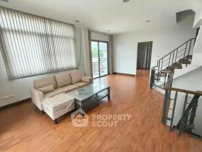 Spacious living room with modern decor and large windows in a stylish apartment.