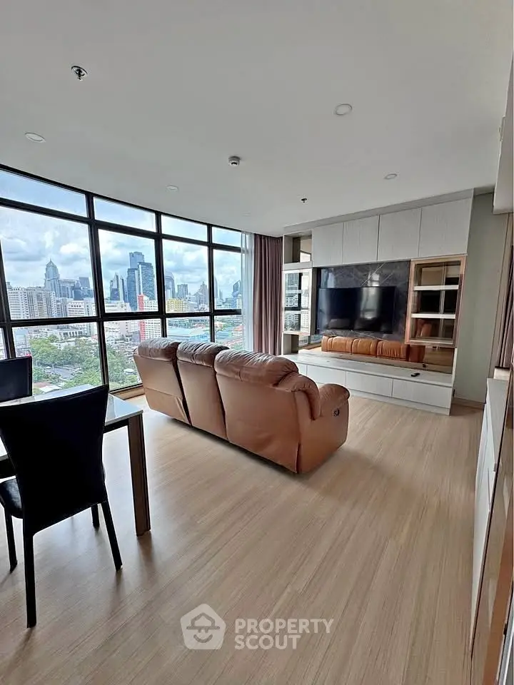 Spacious living room with stunning city view, modern furnishings, and large windows for natural light.