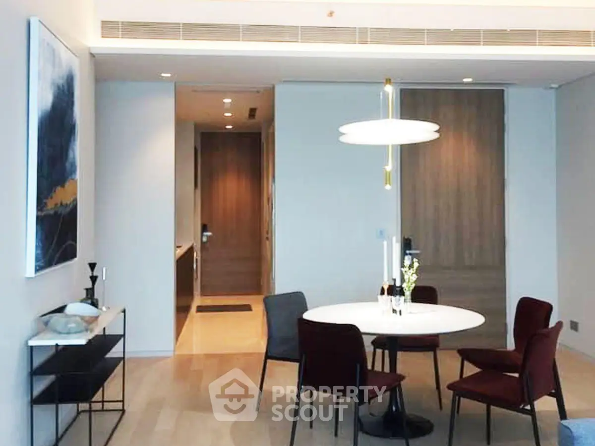 Modern dining area with elegant lighting and contemporary decor in a stylish apartment.