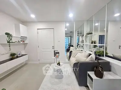 Modern living room with stylish decor and mirrored wall for spacious feel.