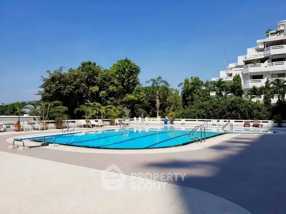 Luxurious outdoor pool area with lush greenery and modern architecture.