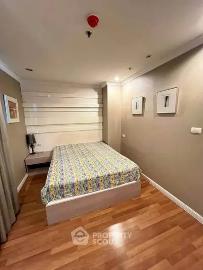 Cozy bedroom with modern decor and wooden flooring in a stylish apartment.