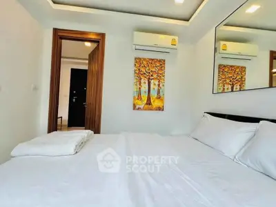 Modern bedroom with white bedding, wall art, and air conditioning unit.