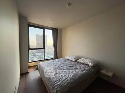 Spacious bedroom with large window offering stunning city views, perfect for urban living.