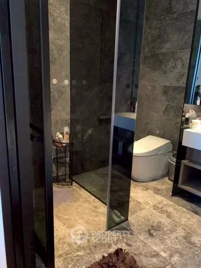 Luxurious modern bathroom with sleek design and elegant stone tiles.