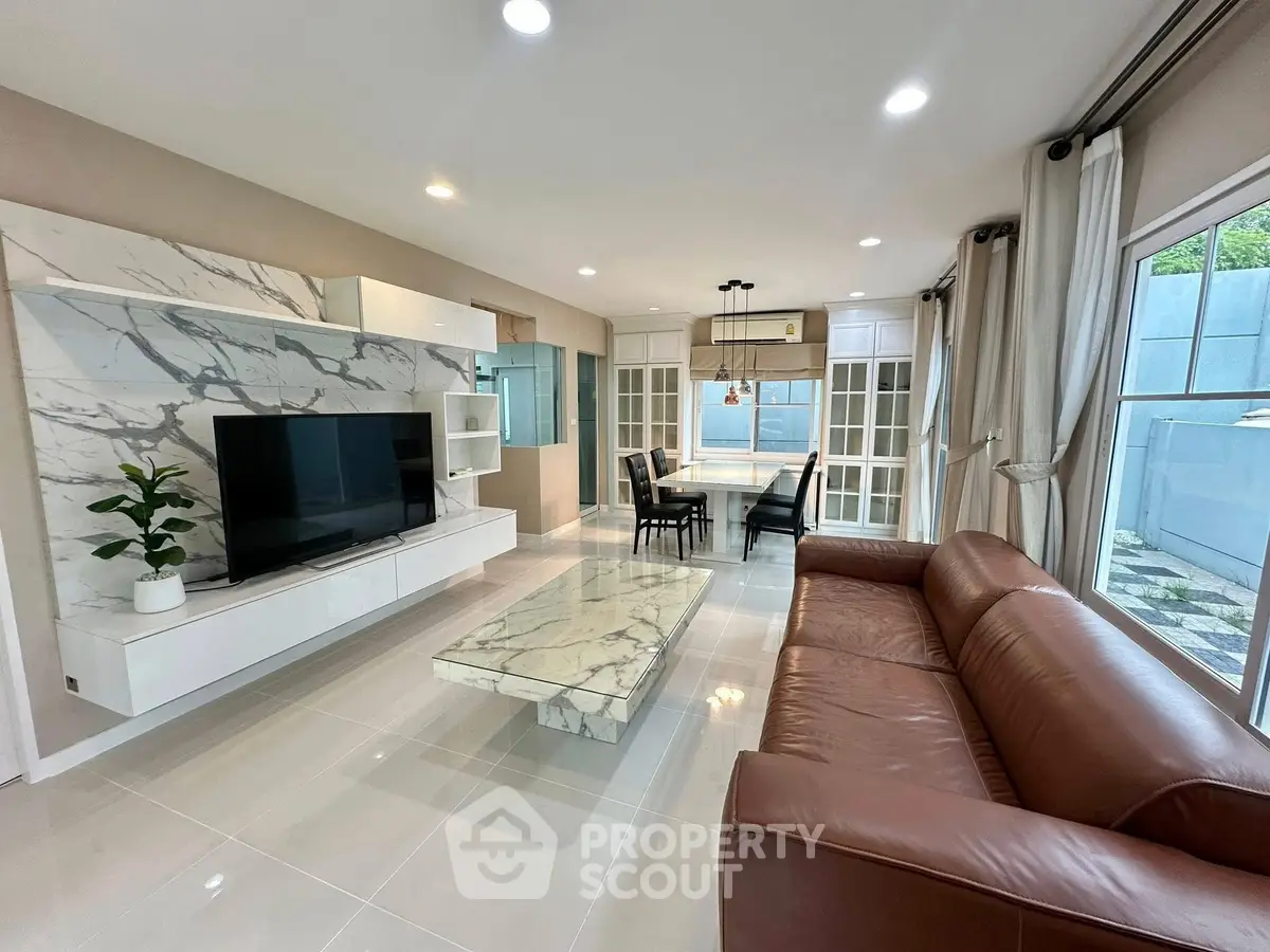 Spacious modern living room with marble accents and large windows.