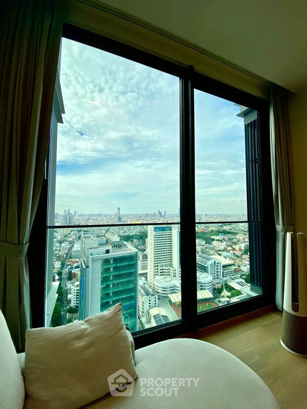 Stunning high-rise apartment with panoramic city view from large window, perfect for urban living.