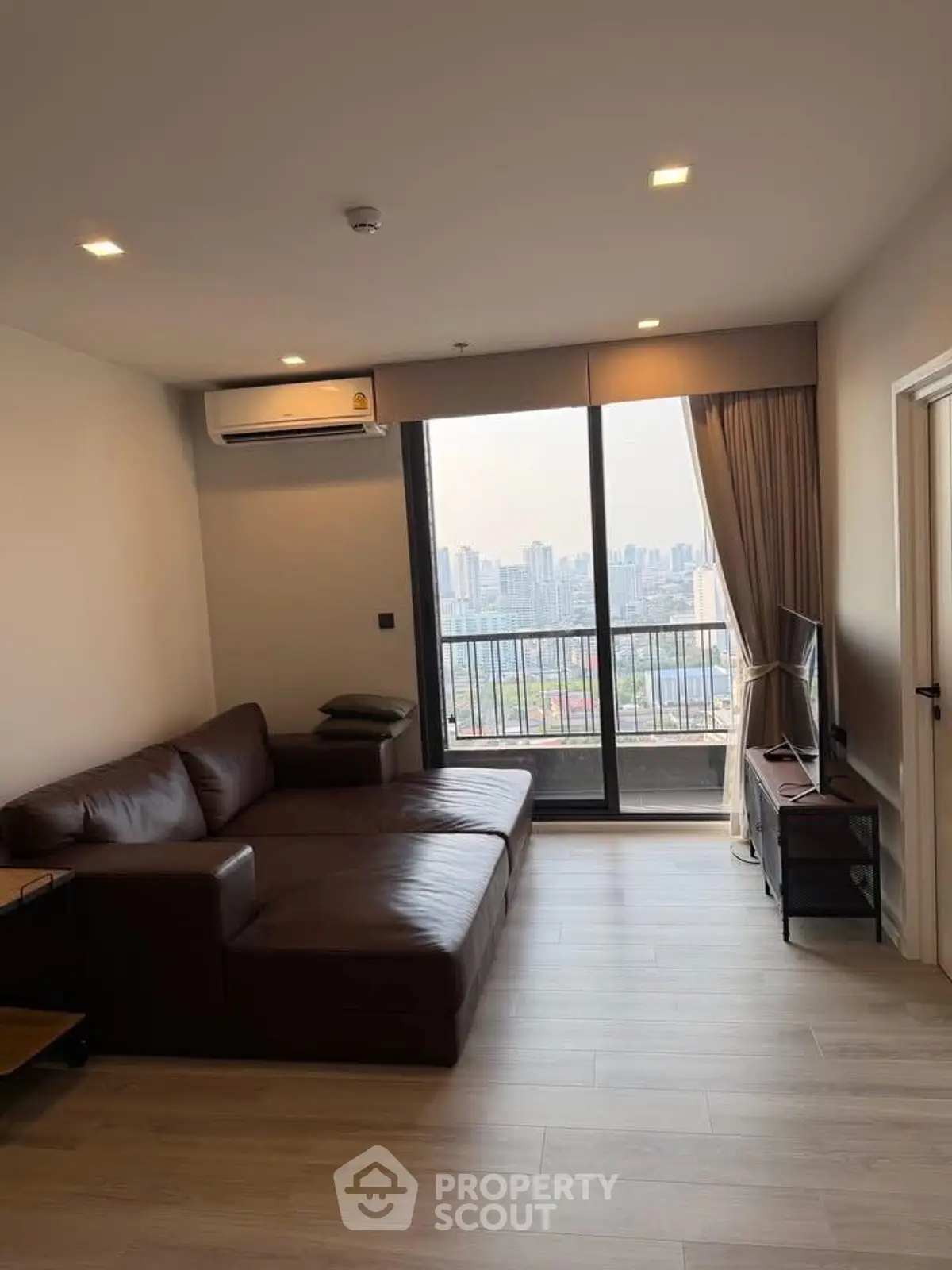 Modern living room with city view and brown leather sofa