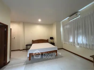 Spacious bedroom with natural light and air conditioning