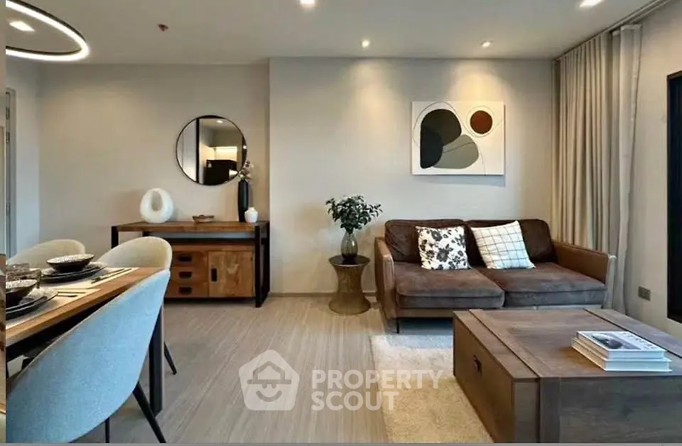 Modern living room with stylish decor and dining area, featuring contemporary furniture and elegant lighting.