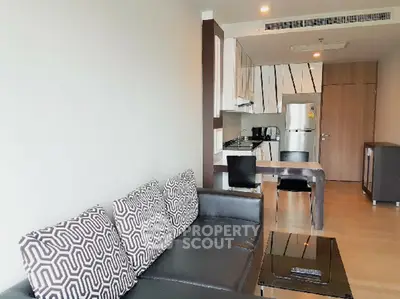 Modern open-layout living room with stylish kitchen and sleek furniture