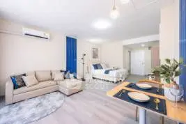 Spacious open-plan living room with modern decor and cozy seating area.