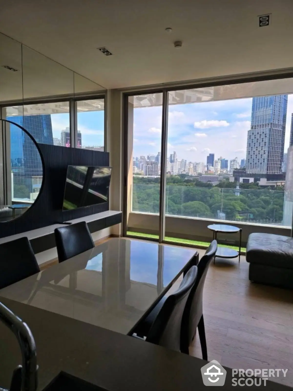 Luxurious modern living room with stunning city skyline view and elegant furnishings.