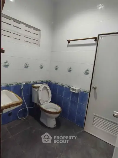 Spacious bathroom with modern fixtures and tiled walls in a real estate property.