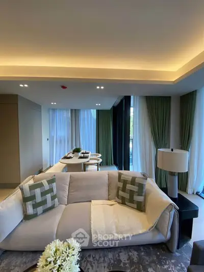 Luxurious modern living room with elegant decor and large windows offering natural light.