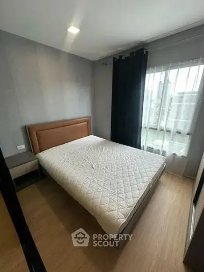 Cozy bedroom with modern decor and large window for natural light
