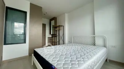 Modern minimalist bedroom with white metal bed frame and built-in wardrobe, perfect for urban living.