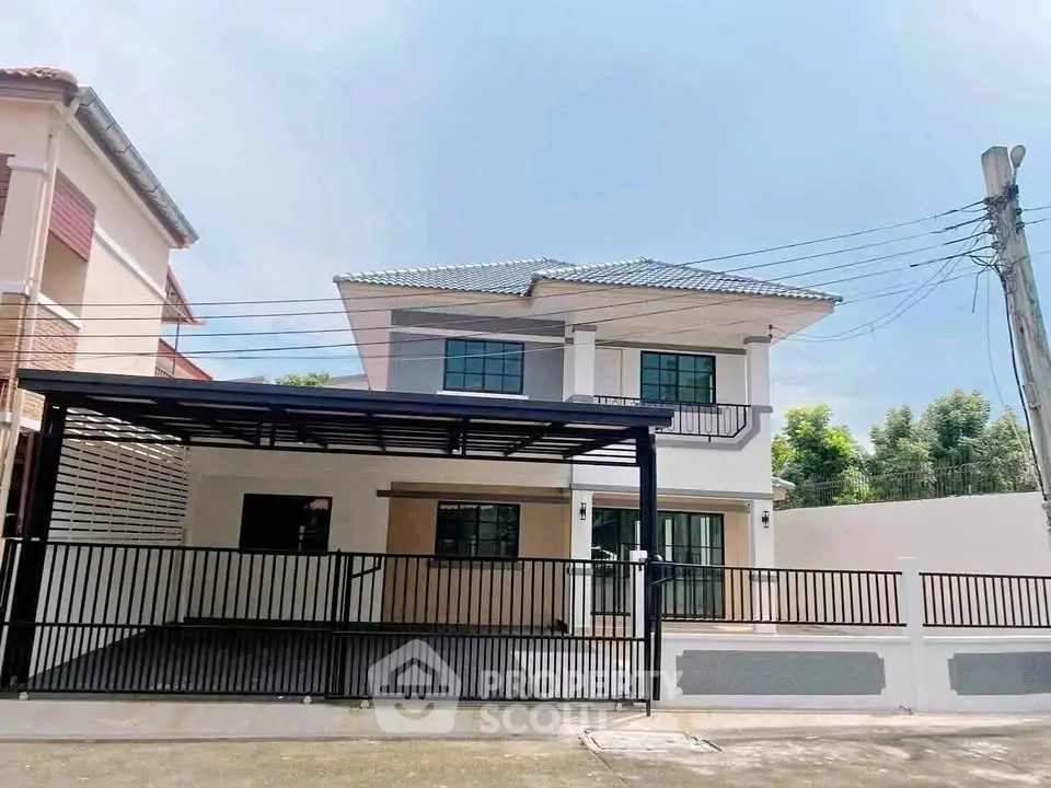 Modern two-story house with spacious driveway and sleek design in a suburban neighborhood.