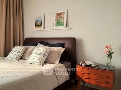 Cozy bedroom with stylish decor and elegant wooden nightstand, perfect for relaxation and comfort.