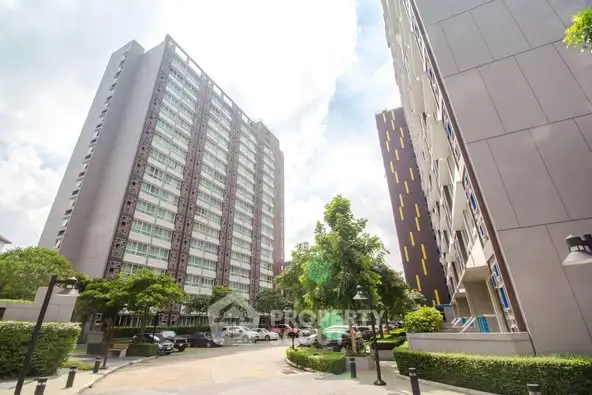 Modern residential buildings with lush greenery and clear sky view.