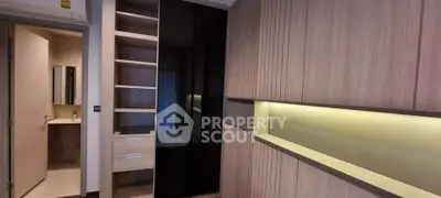 Modern bedroom with sleek built-in wardrobe and view into stylish bathroom