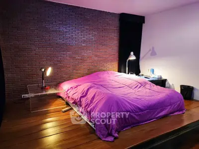 Cozy bedroom with exposed brick wall and modern lighting