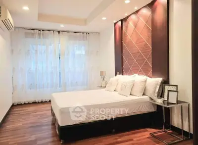 Elegant bedroom with modern decor and hardwood floors in a stylish apartment.
