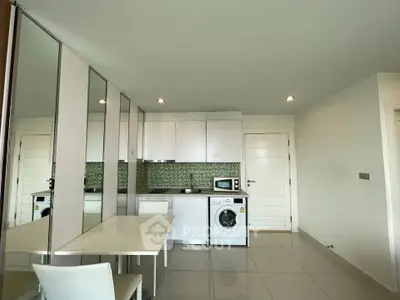 Modern kitchen with sleek white cabinets, washing machine, and stylish backsplash in a bright apartment.