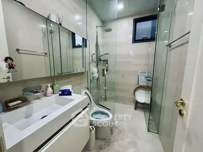 Modern bathroom with glass shower, sleek vanity, and contemporary fixtures.