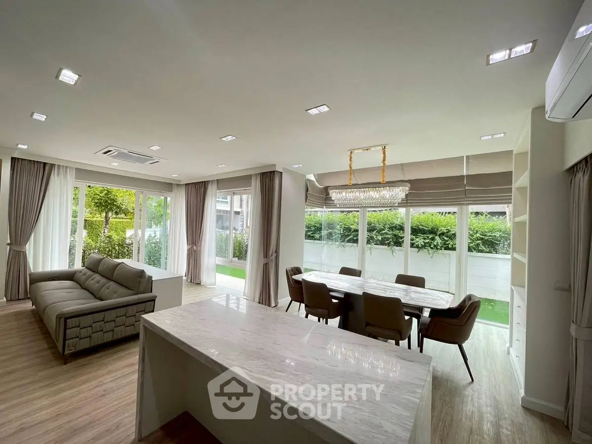 Spacious modern living room with open layout and garden view, featuring elegant dining area and luxurious finishes.