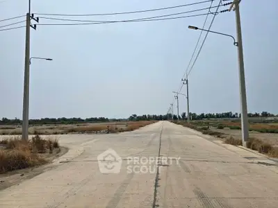 Expansive undeveloped land with potential for real estate development, featuring clear skies and utility poles.