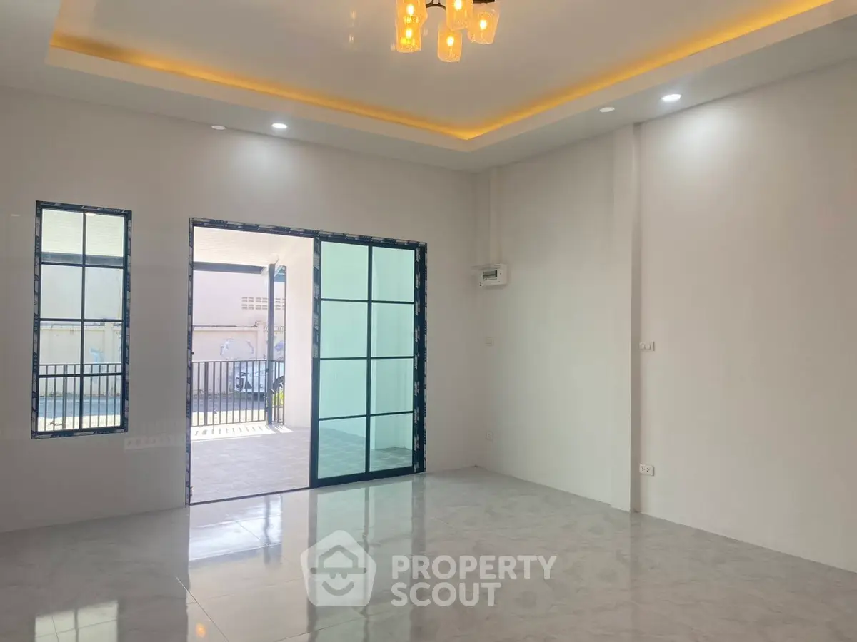 Spacious modern living room with large windows and elegant lighting