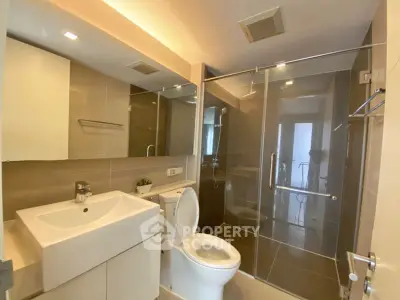 Modern bathroom with glass shower and sleek fixtures in a contemporary apartment.