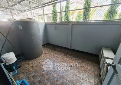 Spacious outdoor utility area with water tank and air conditioning units, ideal for practical storage solutions.