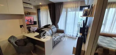 Modern living room with balcony, featuring sleek furniture and natural light.