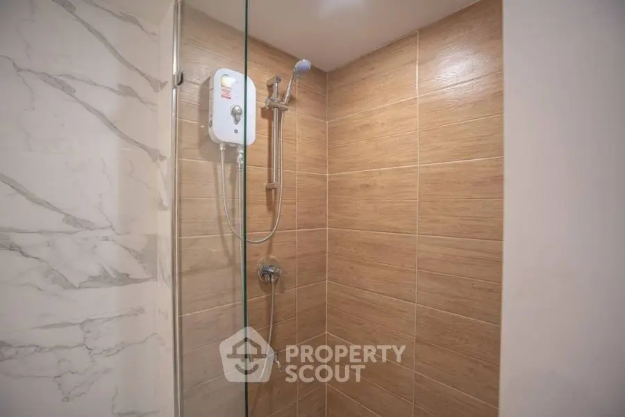 Modern bathroom shower with elegant tile design and sleek fixtures.