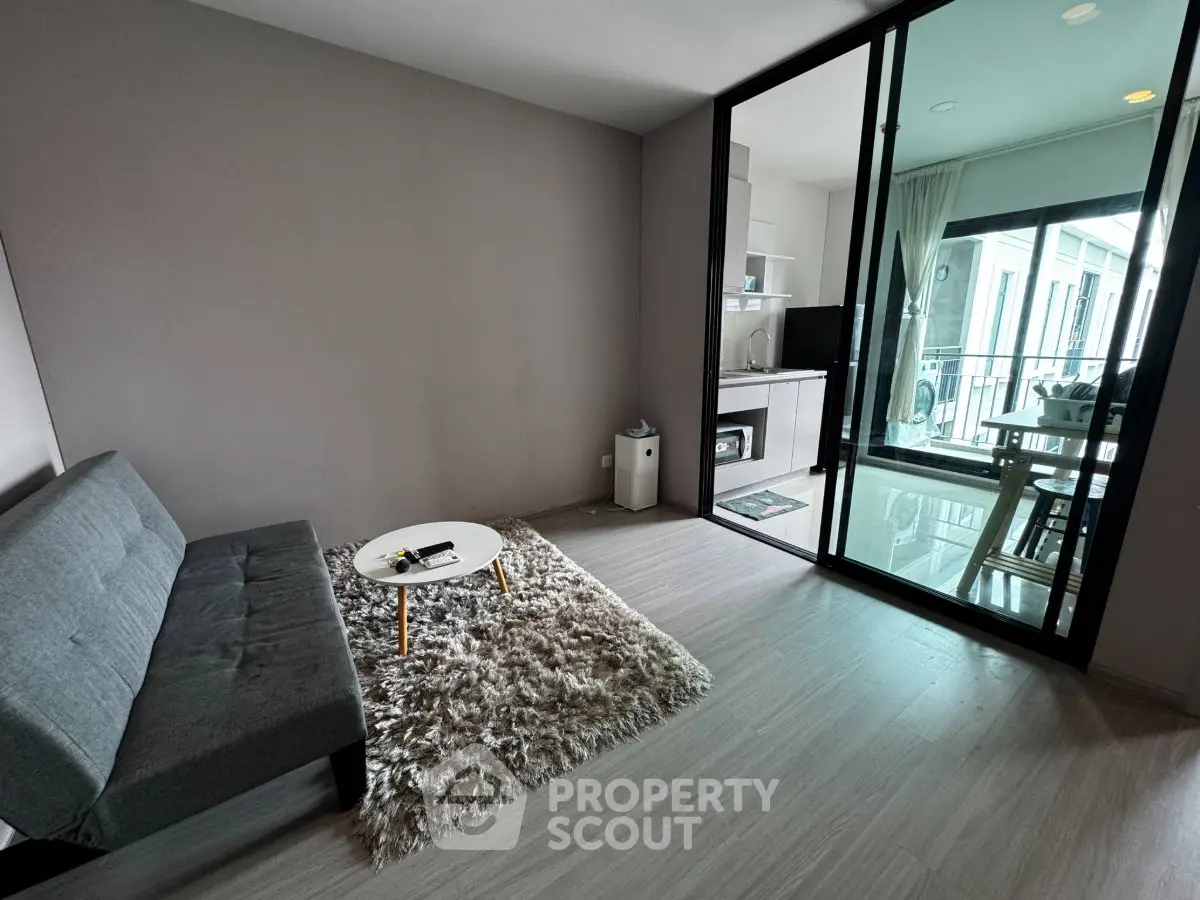 Modern living room with sleek design and balcony view in a stylish apartment.