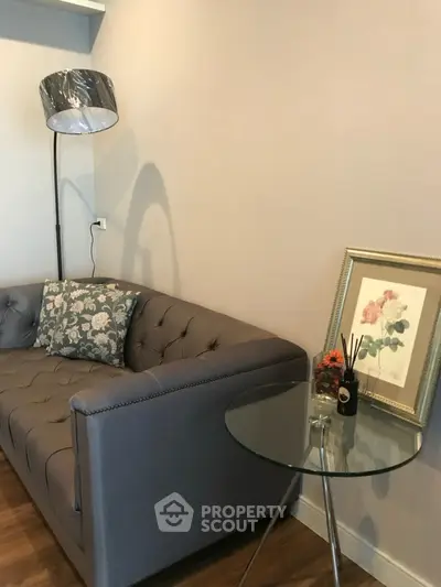 Stylish living room with elegant gray sofa and chic glass side table, perfect for modern interiors.