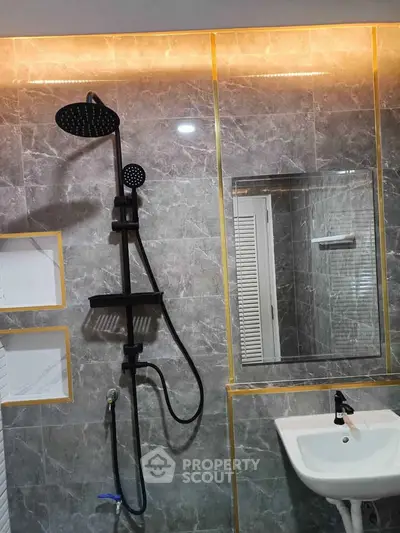 Luxurious modern bathroom with elegant marble tiles and sleek black shower fixtures.