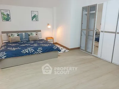 Spacious bedroom with modern decor and large mirrored wardrobe