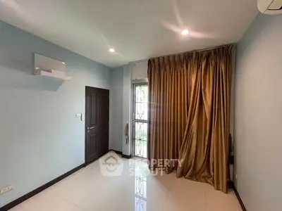 Spacious room with elegant curtains and modern lighting, perfect for a cozy living space.